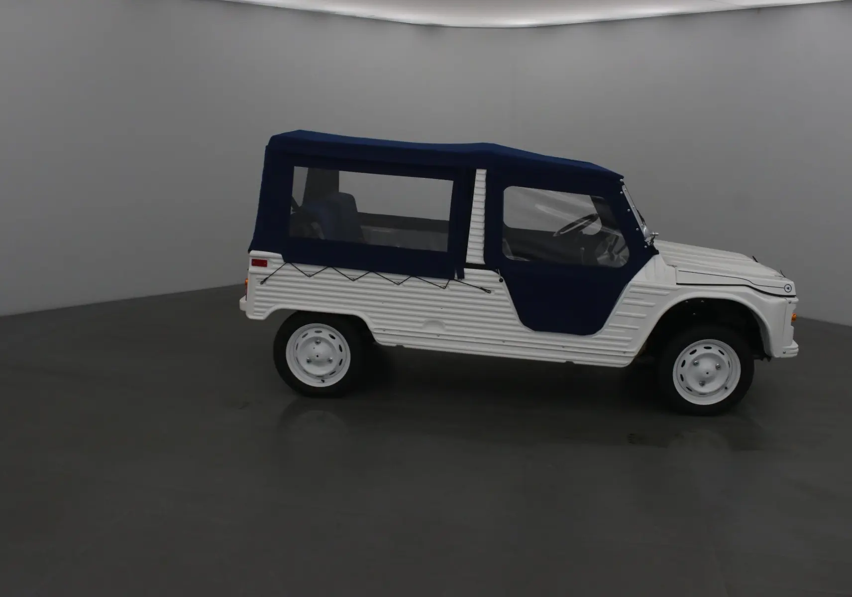 Vue de profil droit du MLT E-STORY ICONE 2024 blanc avec toit et portes souples bleu marine.