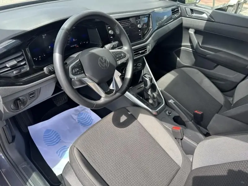 Intérieur de la Volkswagen Polo 1.0 TSI 95 DSG Life 2024, vue côté conducteur, tableau de bord numérique et sièges gris foncé.