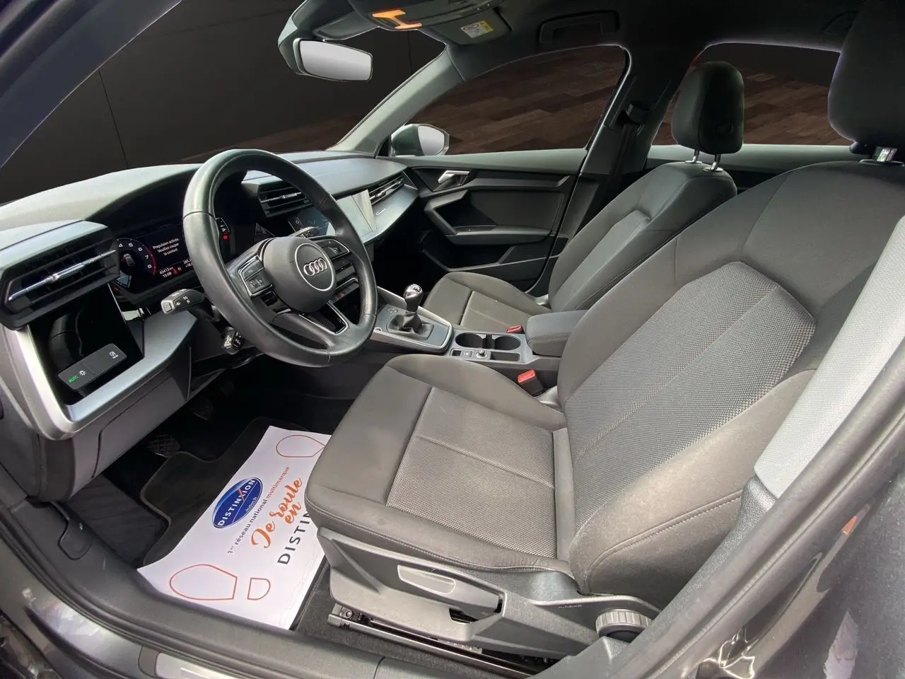 Intérieur noir de l'Audi A3 Sportback 30 TFSI 110 S-Line 2021, vue côté conducteur avec tableau de bord et sièges en tissu.