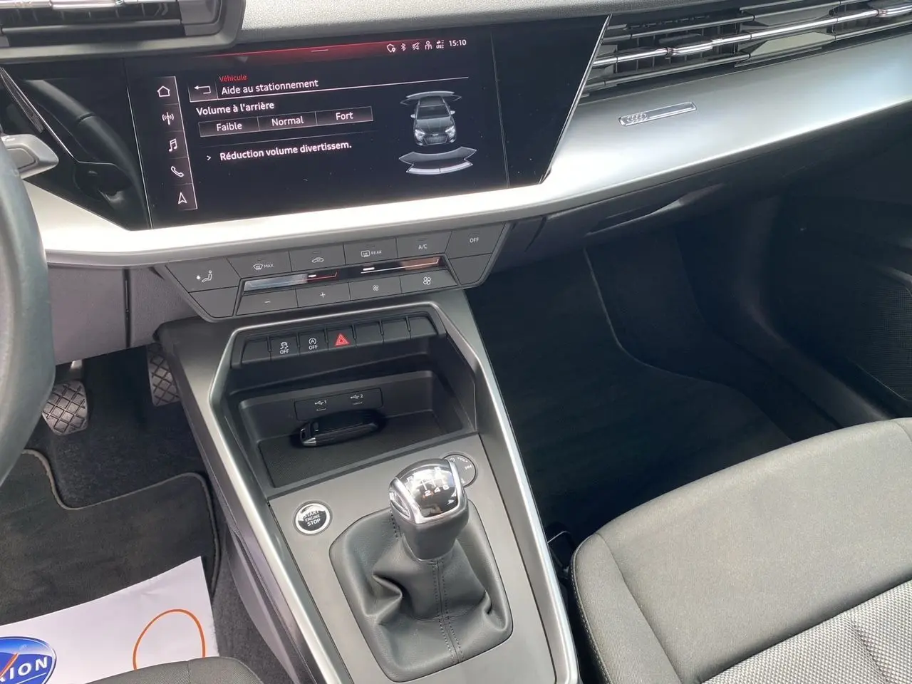 Vue intérieure centrée sur la console centrale et levier de vitesse manuel d'une Audi A3 Sportback 30 TFSI gris Daytona.