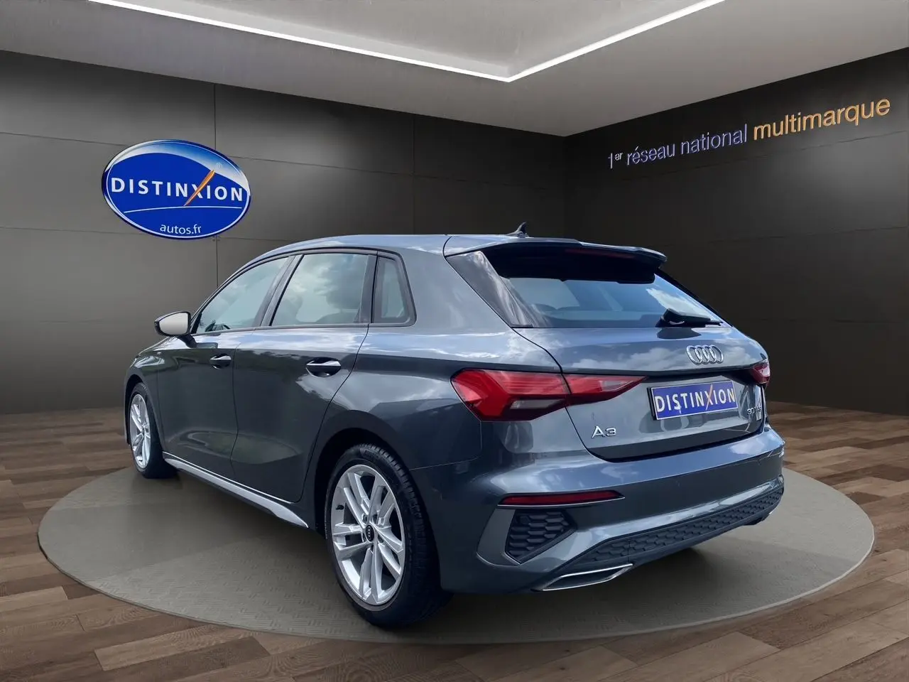 Audi A3 Sportback gris Daytona vue 3/4 arrière droit, avec jantes alliage et feux arrière LED distinctifs.