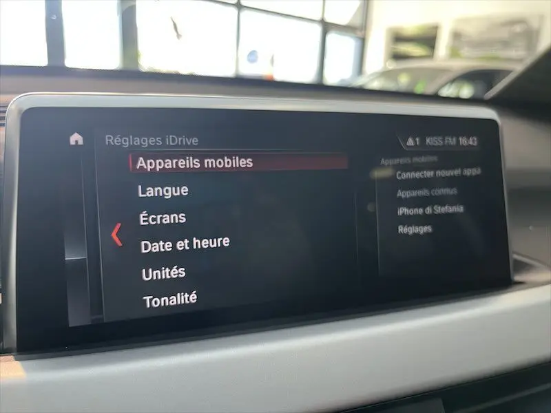 Écran central du système iDrive de BMW X1 25E blanc, affichant les réglages des appareils mobiles en intérieur.