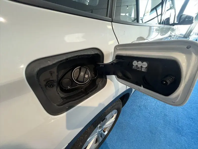 Vue latérale gauche rapprochée du bouchon de réservoir ouvert sur BMW X1 XDRIVE blanc alpin hybride rechargeable.