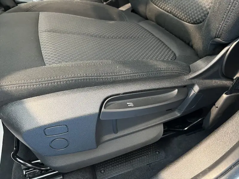 Gros plan sur la commande de réglage manuel du siège avant droit en tissu noir de la BMW X1 XDRIVE 25E 2021