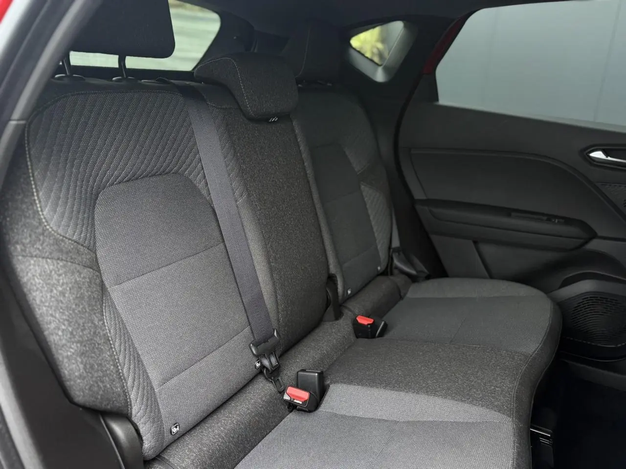 Vue intérieure des sièges arrière gris foncé du Renault Captur 2025, avec ceinture de sécurité et fixation ISOFIX visibles.