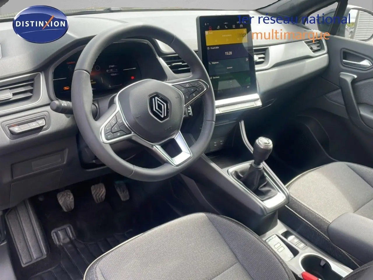 Vue intérieure côté conducteur du Renault Captur gris Cassiopée avec volant multifonction et boîte manuelle.