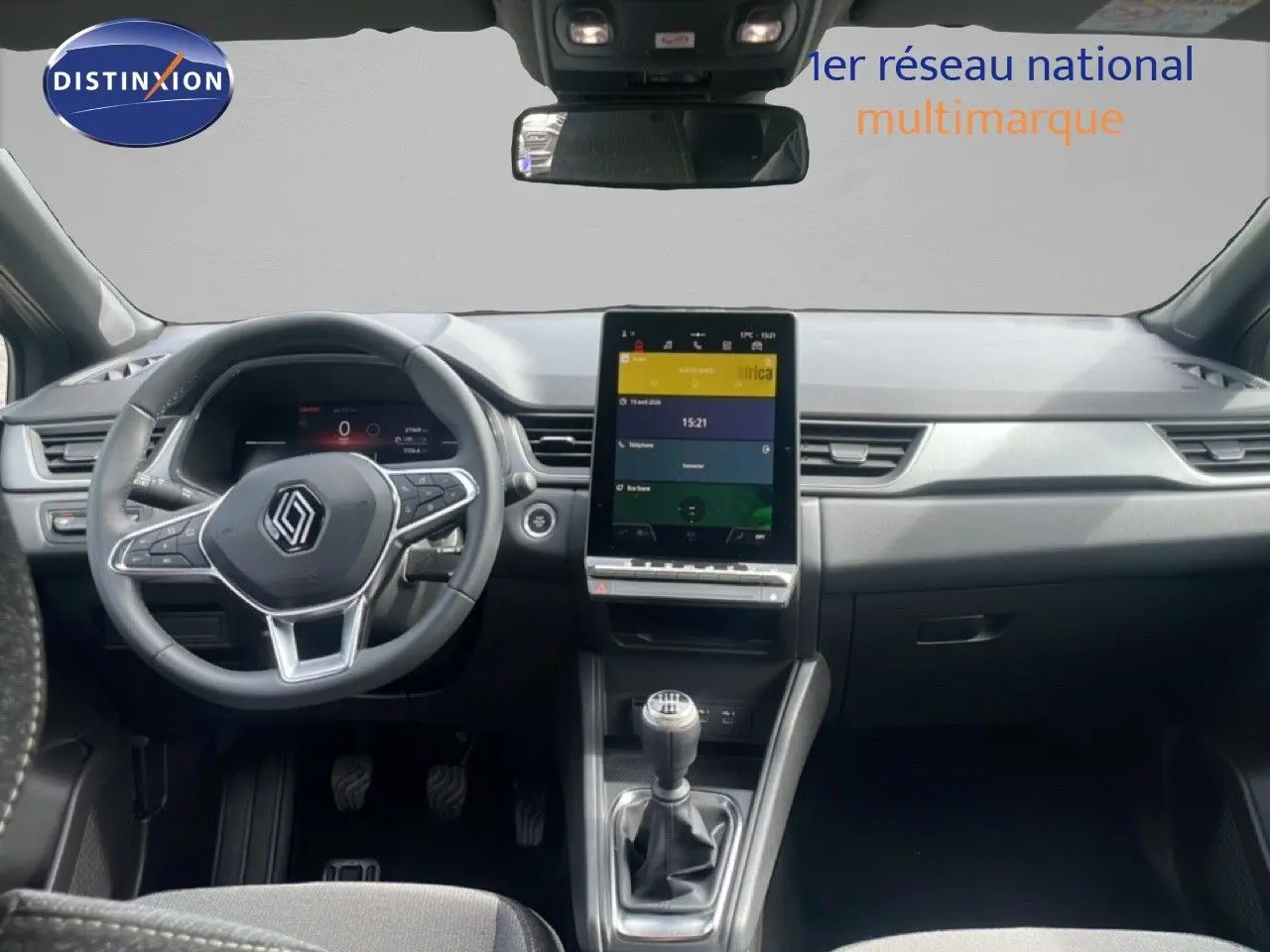 Vue intérieure frontale du tableau de bord du Renault Captur gris Cassiopée, avec écran tactile vertical et boîte manuelle.