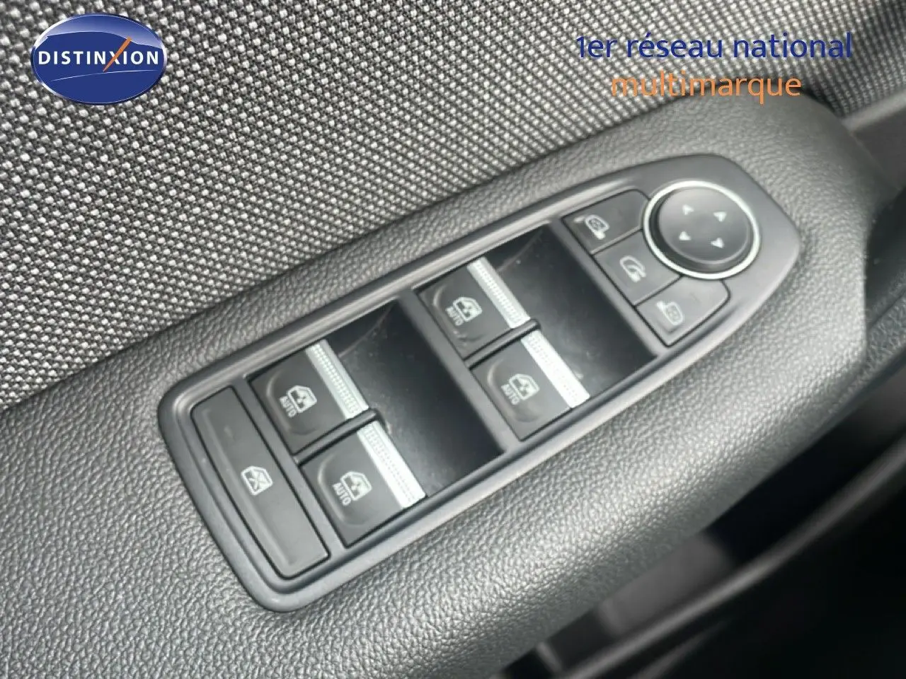 Gros plan sur les commandes des vitres électriques et rétroviseurs côté conducteur du Renault Captur gris cassiopée métal 2025.