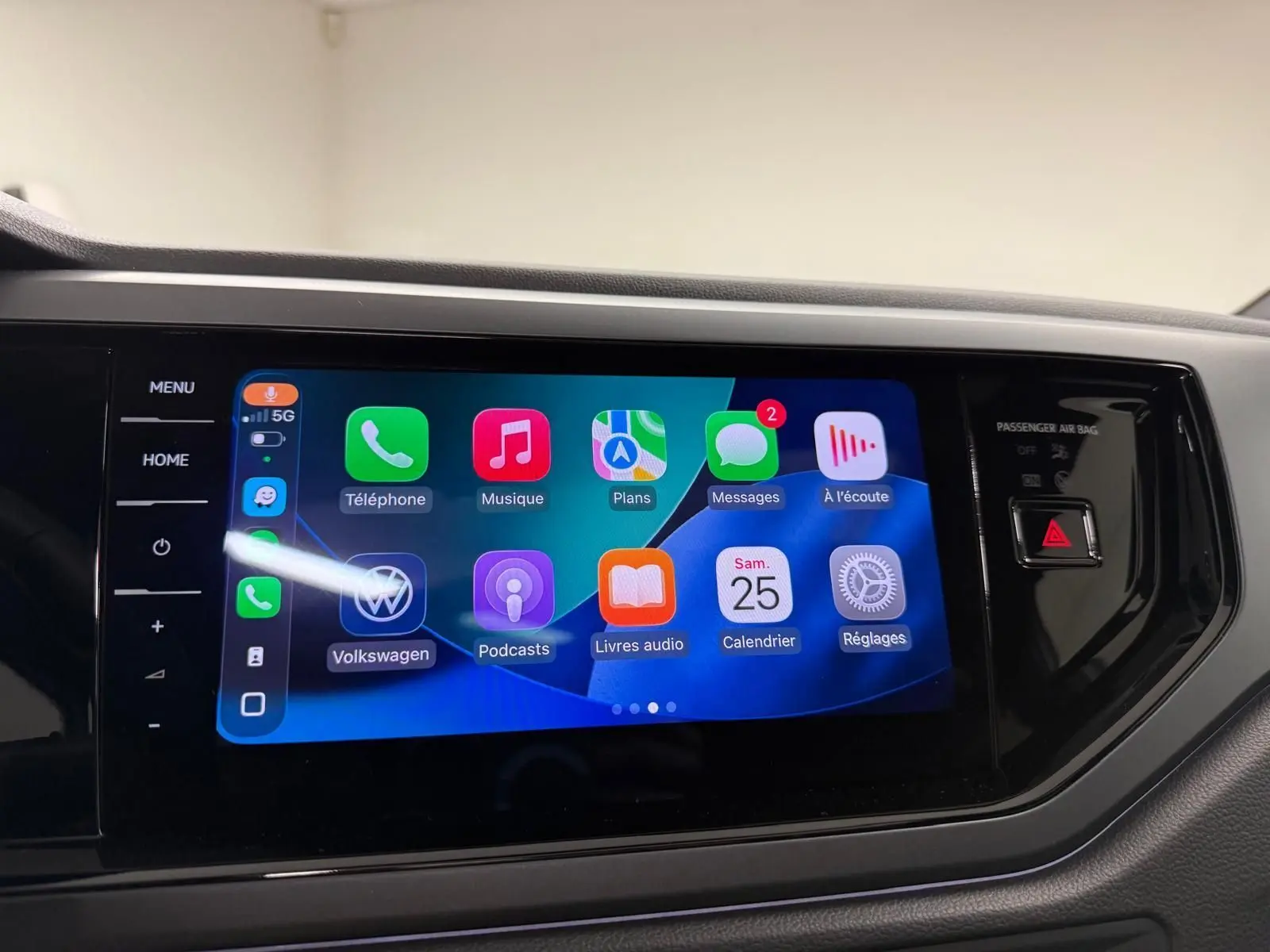 Écran tactile central du Volkswagen Taigo 2025 affichant l'interface Apple CarPlay avec commandes tactiles latérales.