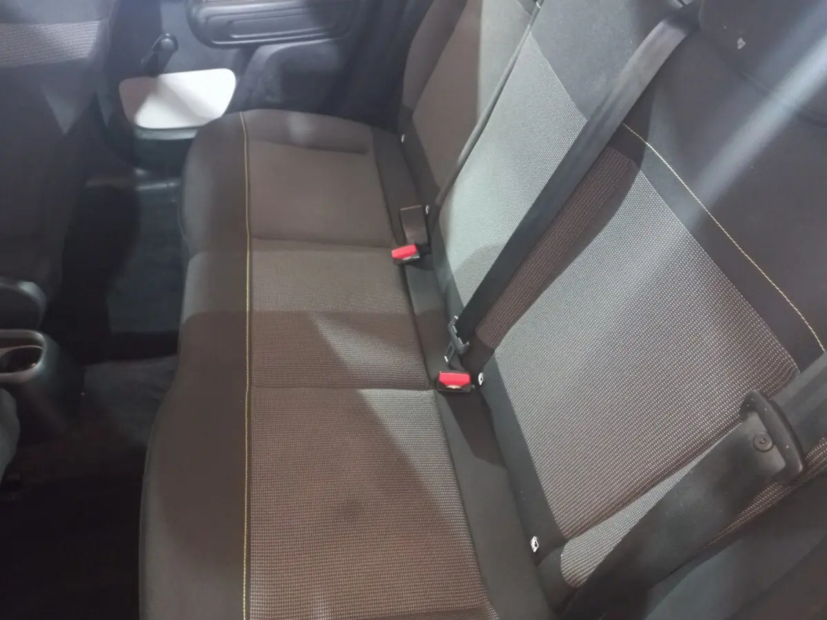 Vue intérieure du siège arrière droit de la Citroën C3 2024 noir, avec ceinture de sécurité et tissu texturé.