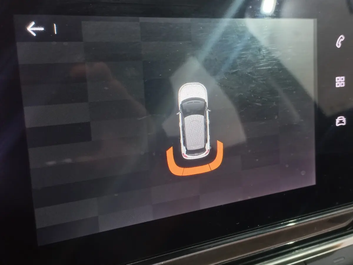 Affichage tactile intérieur montrant une vue de dessus du véhicule noir Citroën C3 avec alerte de proximité arrière en orange.