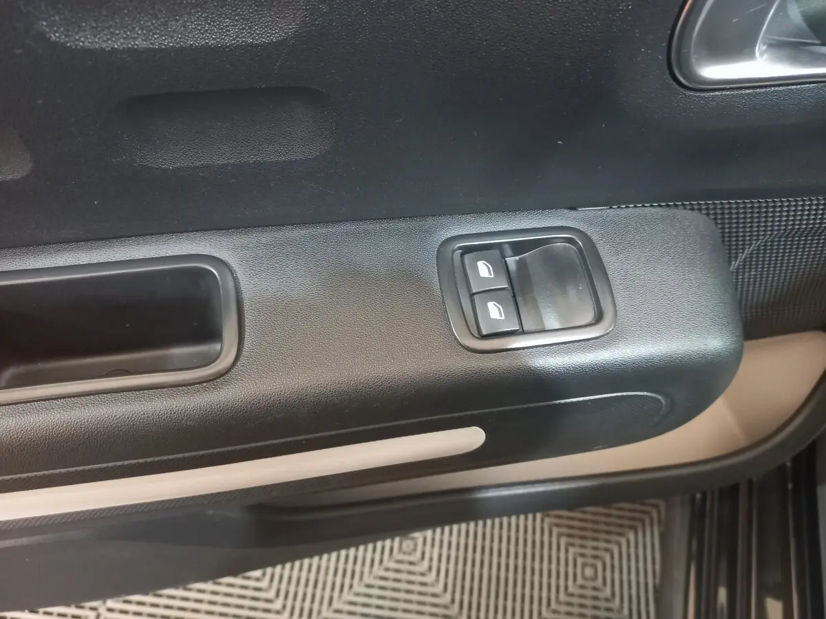 Détail de la porte côté conducteur de la Citroën C3 noire 2024, avec commandes de vitres électriques et poignée intégrée.