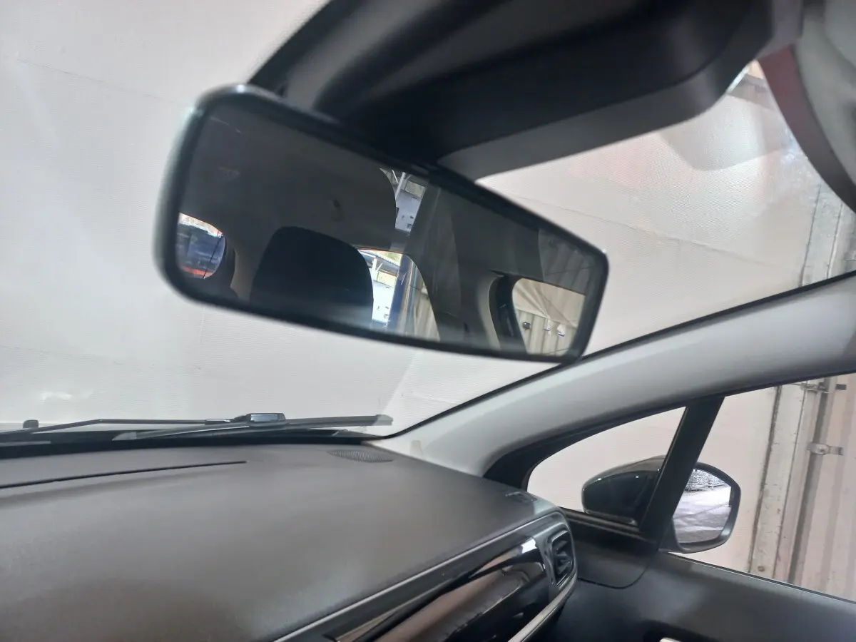 Vue intérieure du tableau de bord et rétroviseur d'une Citroën C3 noire, avec angle droit avant et pare-brise visible.