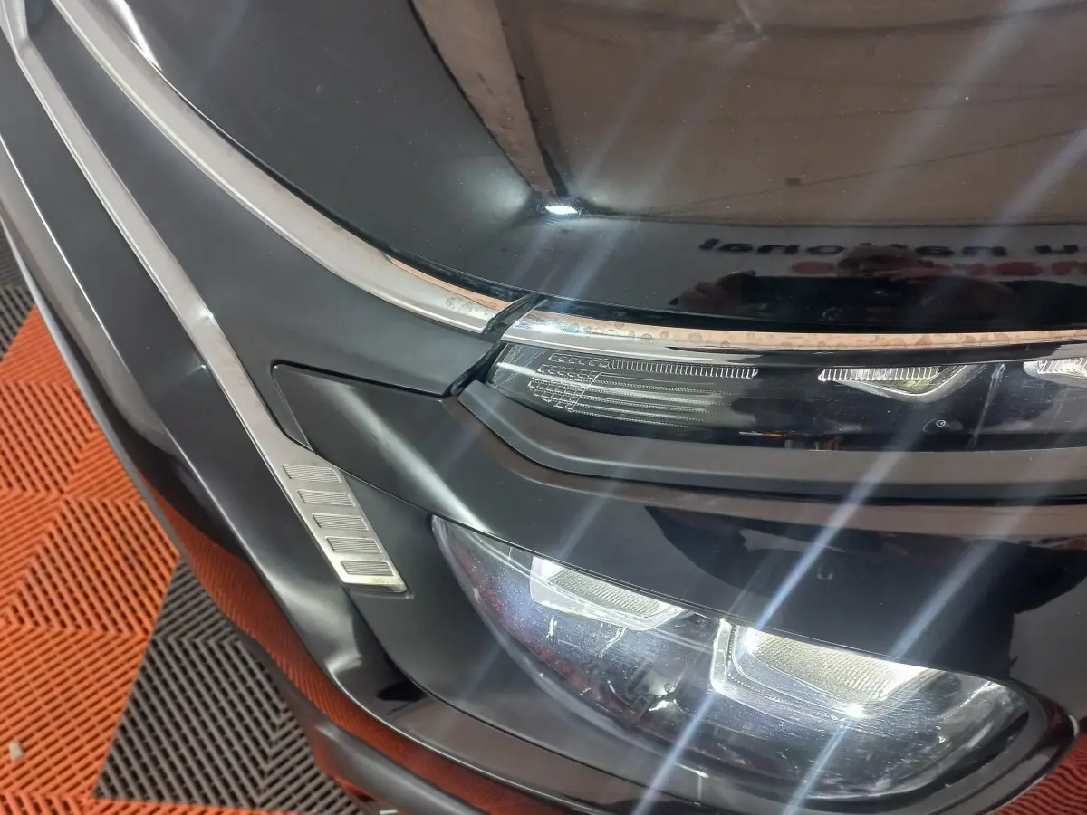Gros plan sur l'avant droit noir brillant d'une Citroën C3 2024, mettant en valeur ses phares LED et détails chromés.