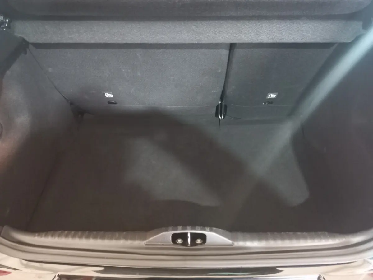 Coffre ouvert vu de dessus de la Citroën C3 noire 2024, montrant l’espace de chargement avec banquette arrière rabattable.