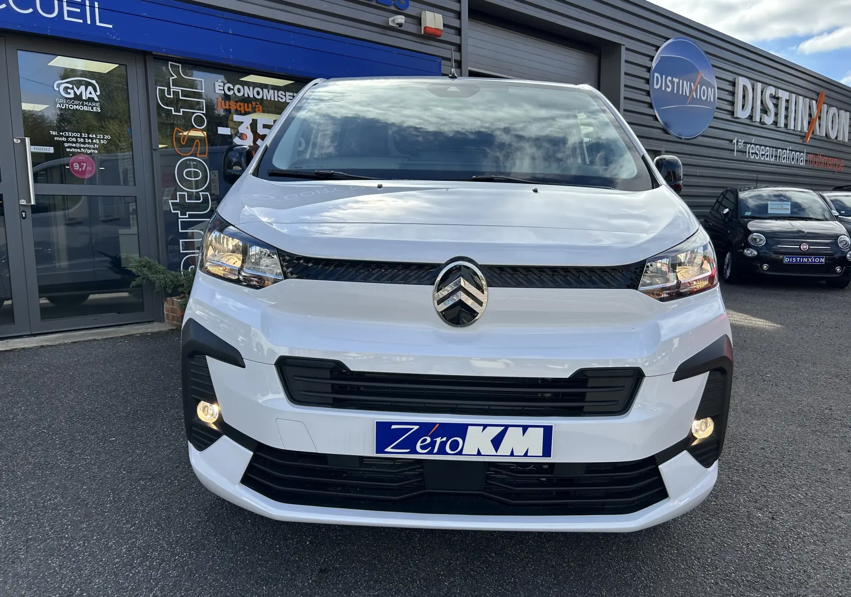 Vue frontale d'un Citroën Jumpy Fourgon blanc 2025 avec phares allumés et plaque Zéro KM visible.