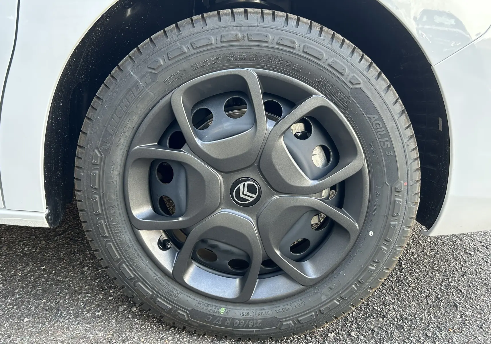 Gros plan sur la roue avant gauche du Citroën Jumpy Fourgon blanc, avec jante en alliage gris foncé au design moderne.