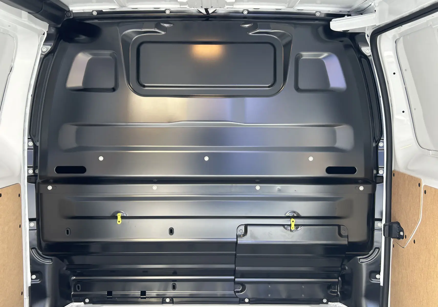 Vue intérieure de la cloison arrière noire du Citroën Jumpy Fourgon blanc 2025, avec panneaux latéraux en bois clair.