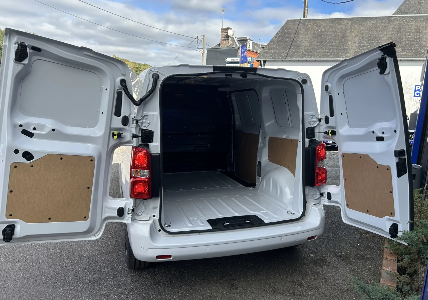 Vue arrière ouverte du Citroën Jumpy Fourgon blanc 2025, montrant l'espace de chargement vide et les portes battantes ouvertes.