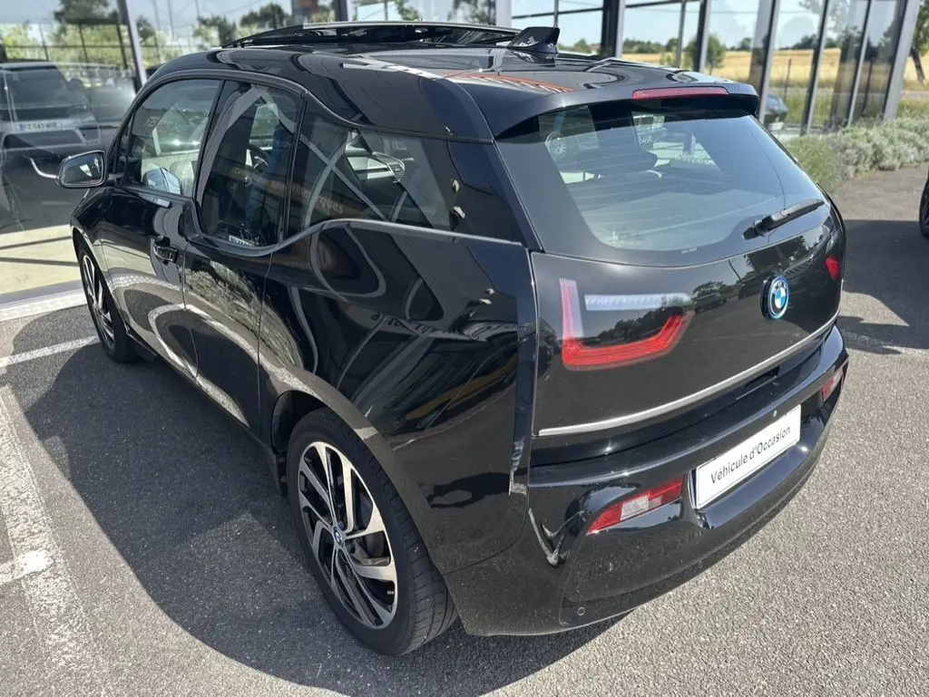 Vue 3/4 arrière droite d'une BMW i3 noire 2022 avec feux LED distinctifs et jantes alliage modernes.