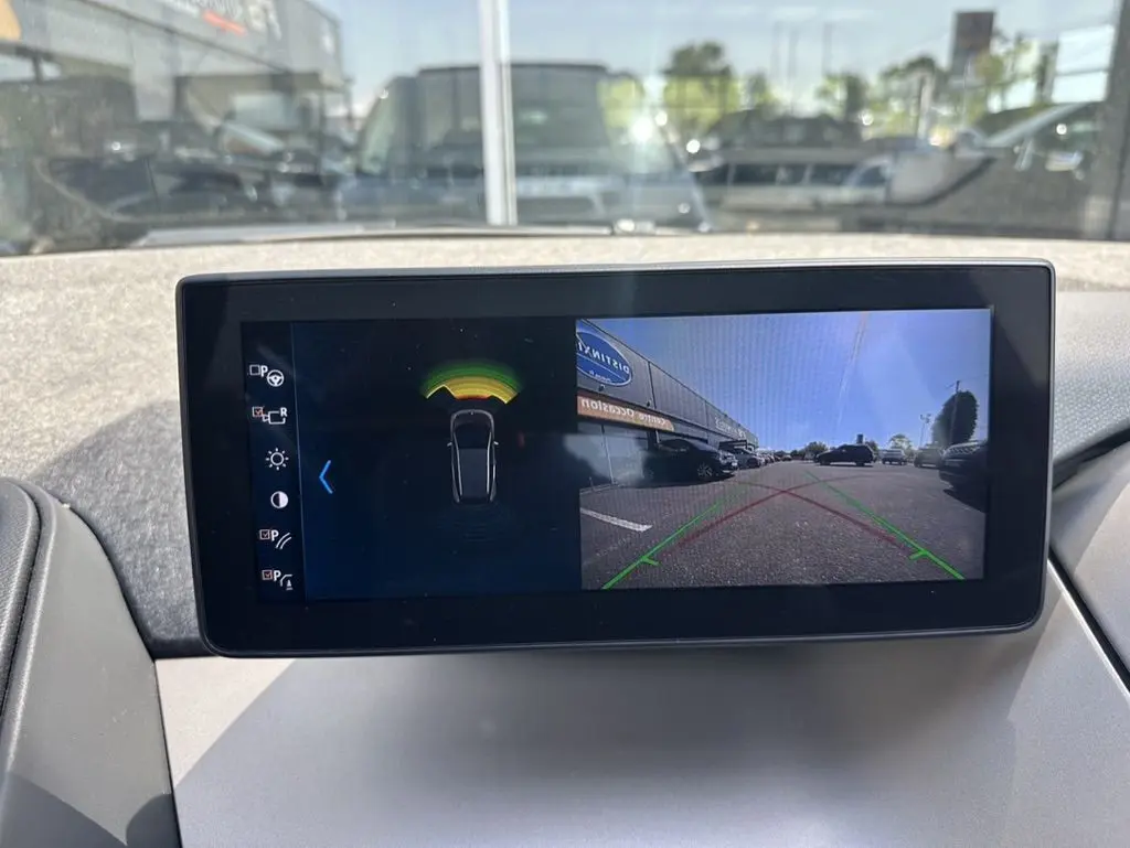 Écran central de BMW i3 2022 noir montrant l'affichage caméra de recul et capteurs de stationnement.