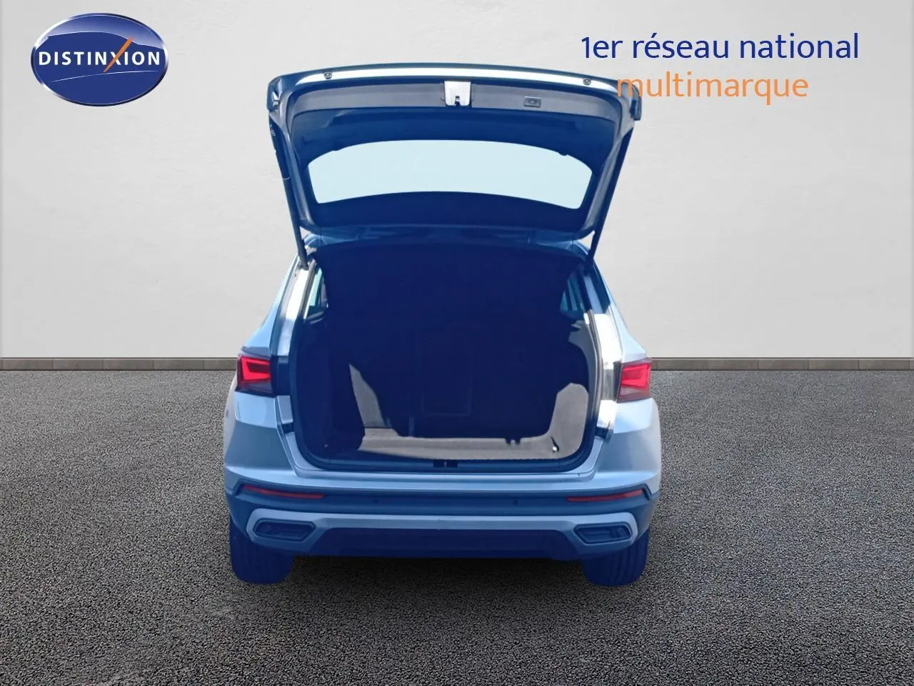 Vue arrière d'un SEAT Ateca argent Reflex Metal 2023 avec coffre ouvert montrant l'espace de chargement.