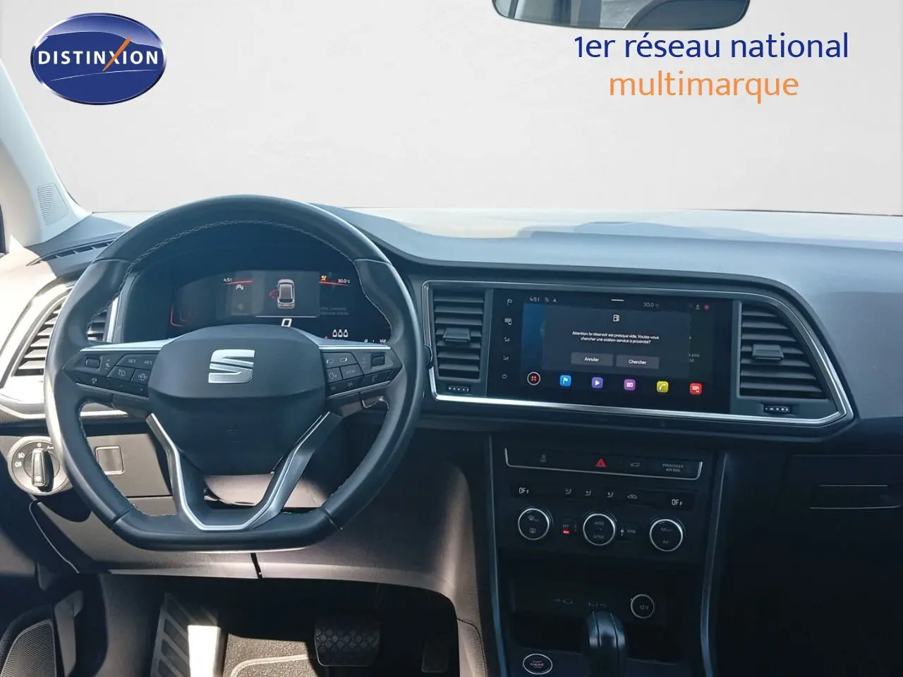 Vue frontale de l'habitacle du SEAT Ateca 2023, tableau de bord noir avec écran tactile et volant multifonction.