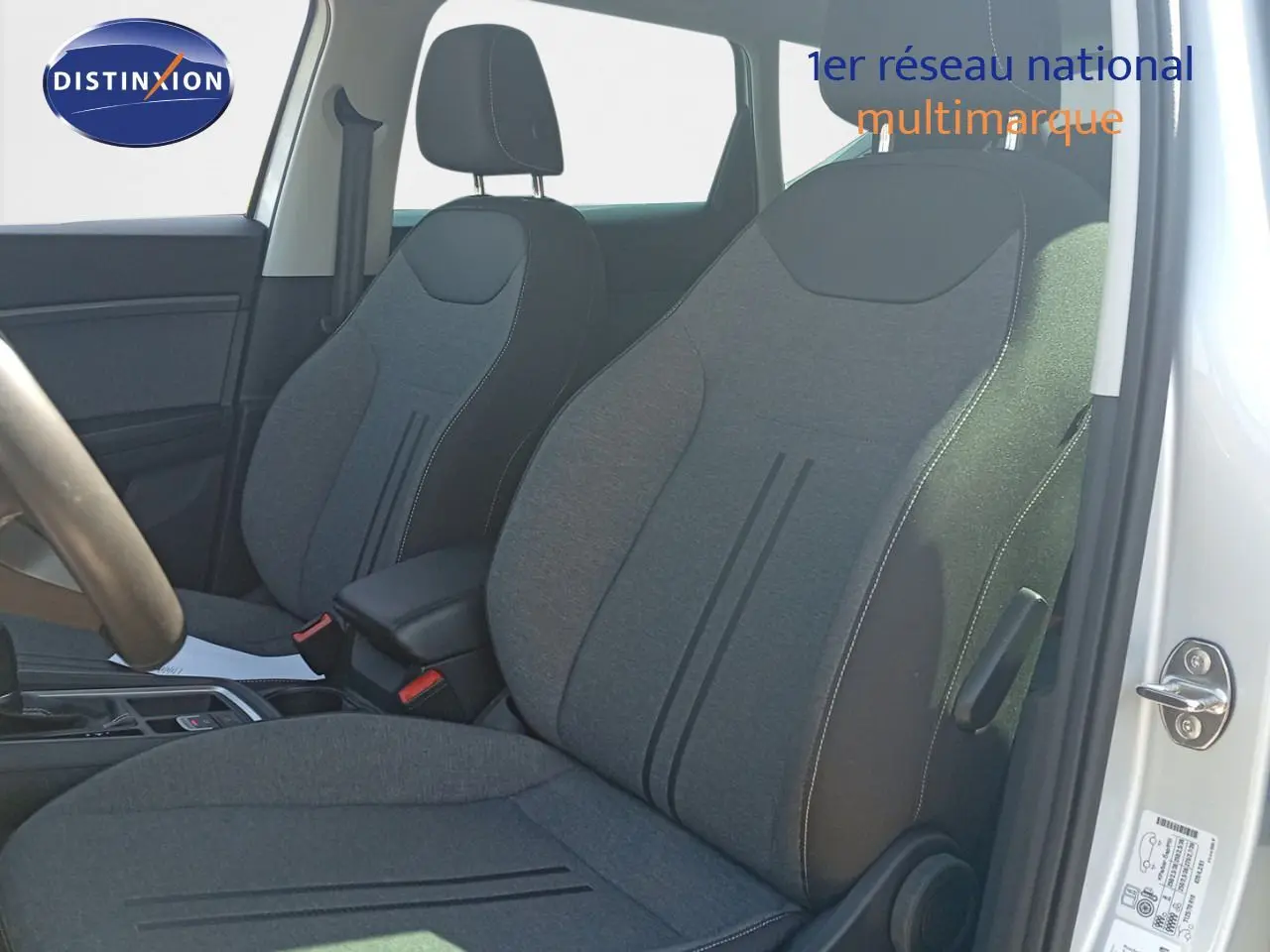 Intérieur du SEAT Ateca 2023 en vue côté gauche, montrant les sièges en tissu gris et la portière argentée ouverte.