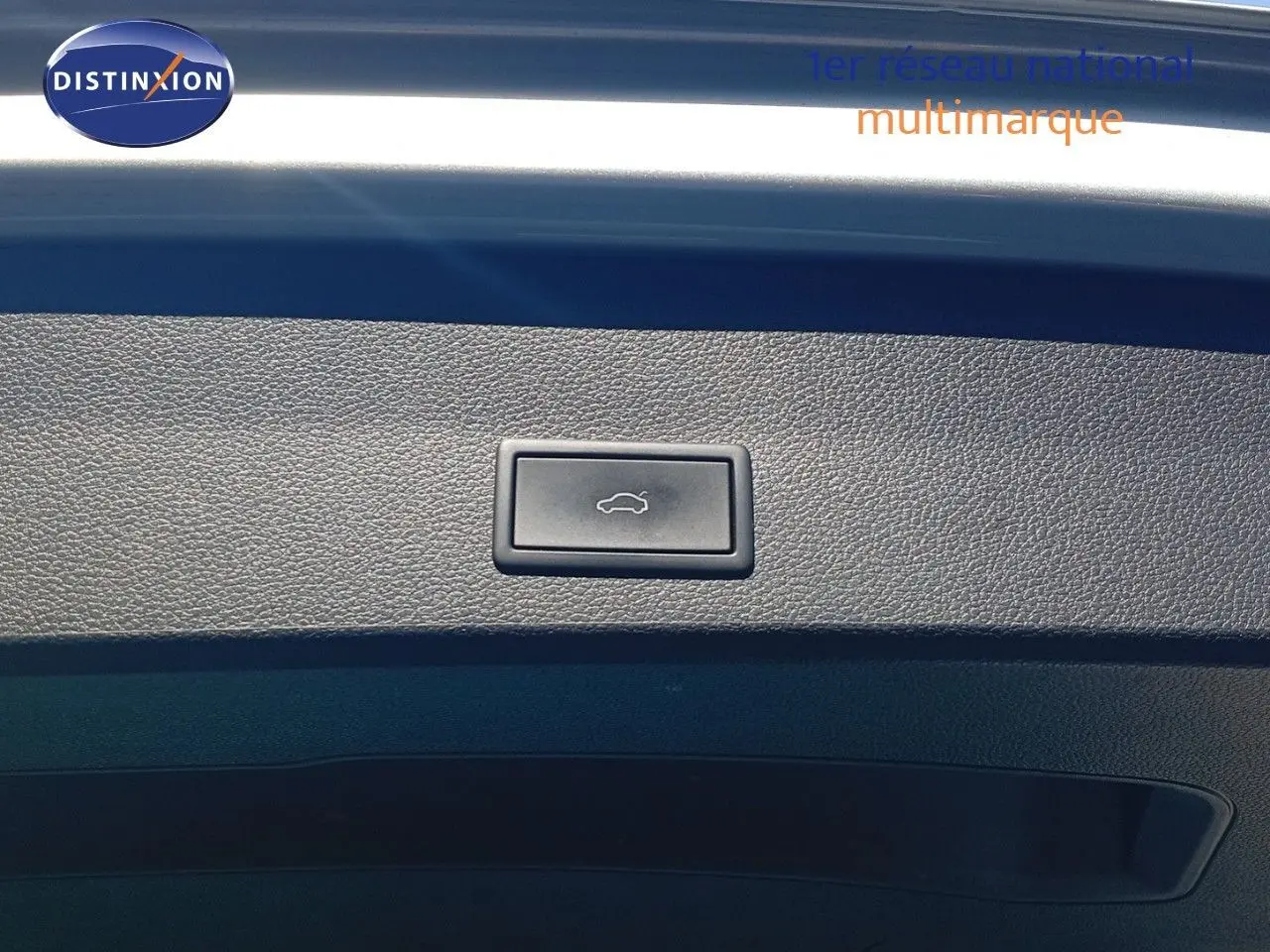 Bouton d'ouverture du coffre sur la garniture intérieure du hayon d'un SEAT Ateca argent 2023.