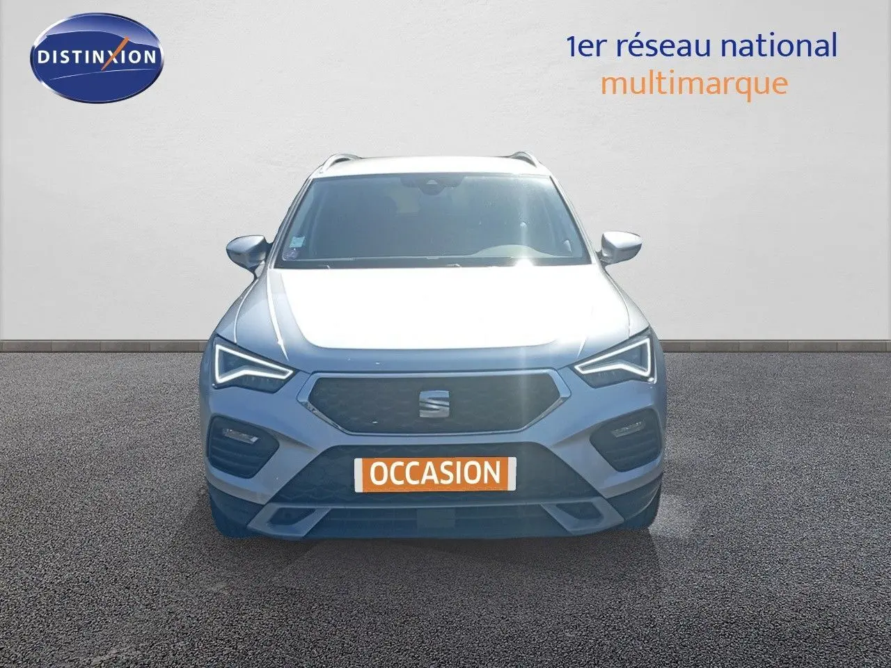 Vue frontale d'un SEAT Ateca argent reflex metal 2023 avec feux LED et plaque occasion visible.