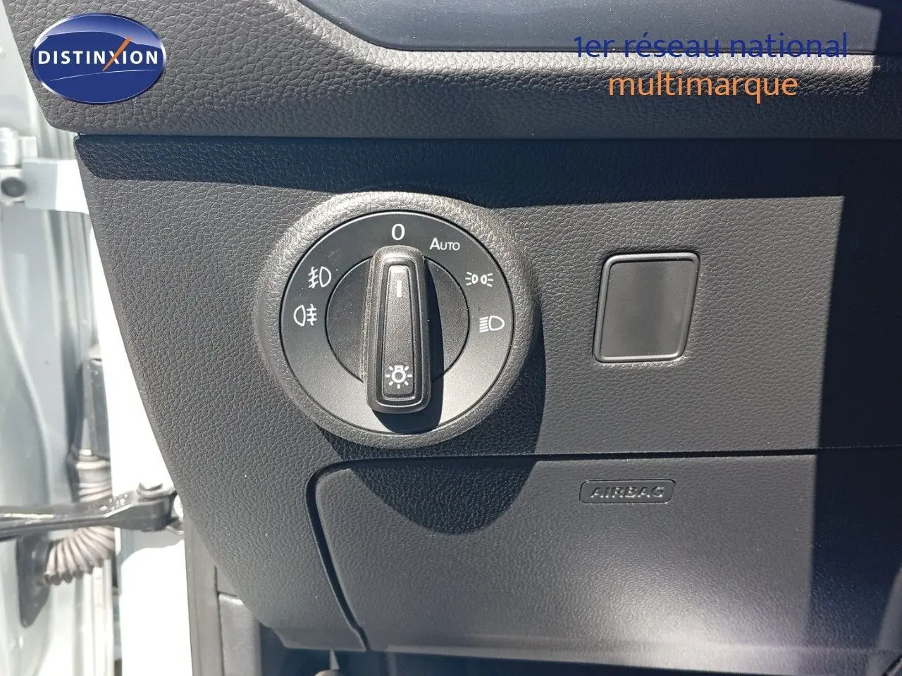 Gros plan sur le bouton de commande des phares à gauche du tableau de bord du SEAT Ateca argent 2023.