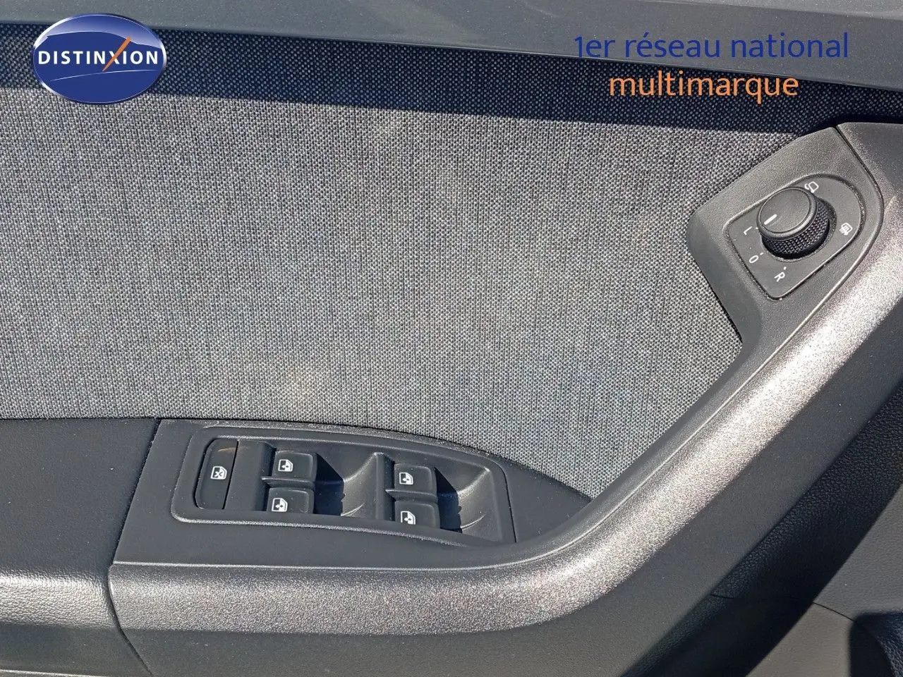 Gros plan sur la commande des vitres et réglages des rétroviseurs côté conducteur du SEAT Ateca gris intérieur tissu.