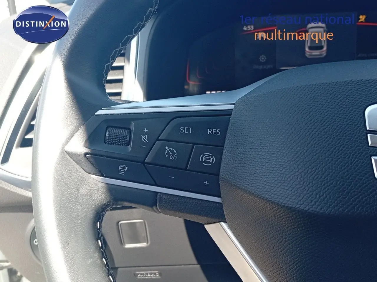 Gros plan sur le volant cuir noir du SEAT Ateca 2023 avec commandes intégrées et tableau de bord digital en arrière-plan.