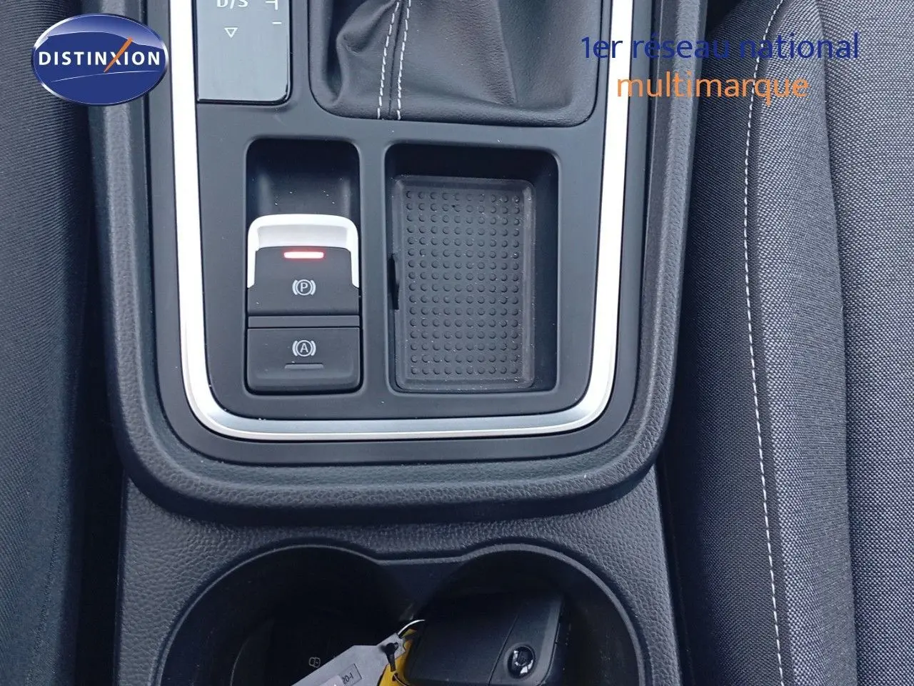 Vue rapprochée de la console centrale du SEAT Ateca 2023 argent, avec commandes électroniques et porte-gobelets.