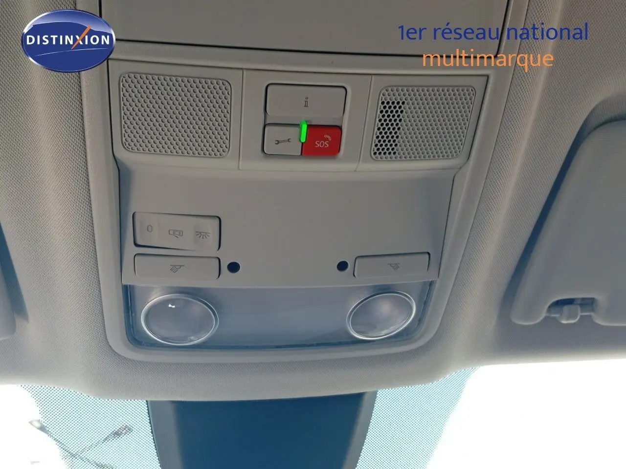 Vue intérieure du plafonnier gris clair du SEAT Ateca 2023, avec commandes d'éclairage et bouton SOS rouge.