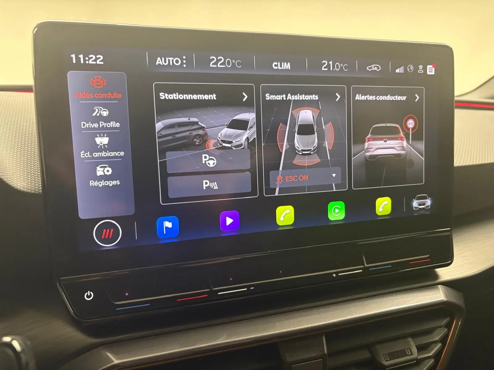 Écran tactile intérieur du CUPRA Leon 2024 montrant les aides à la conduite et la climatisation.