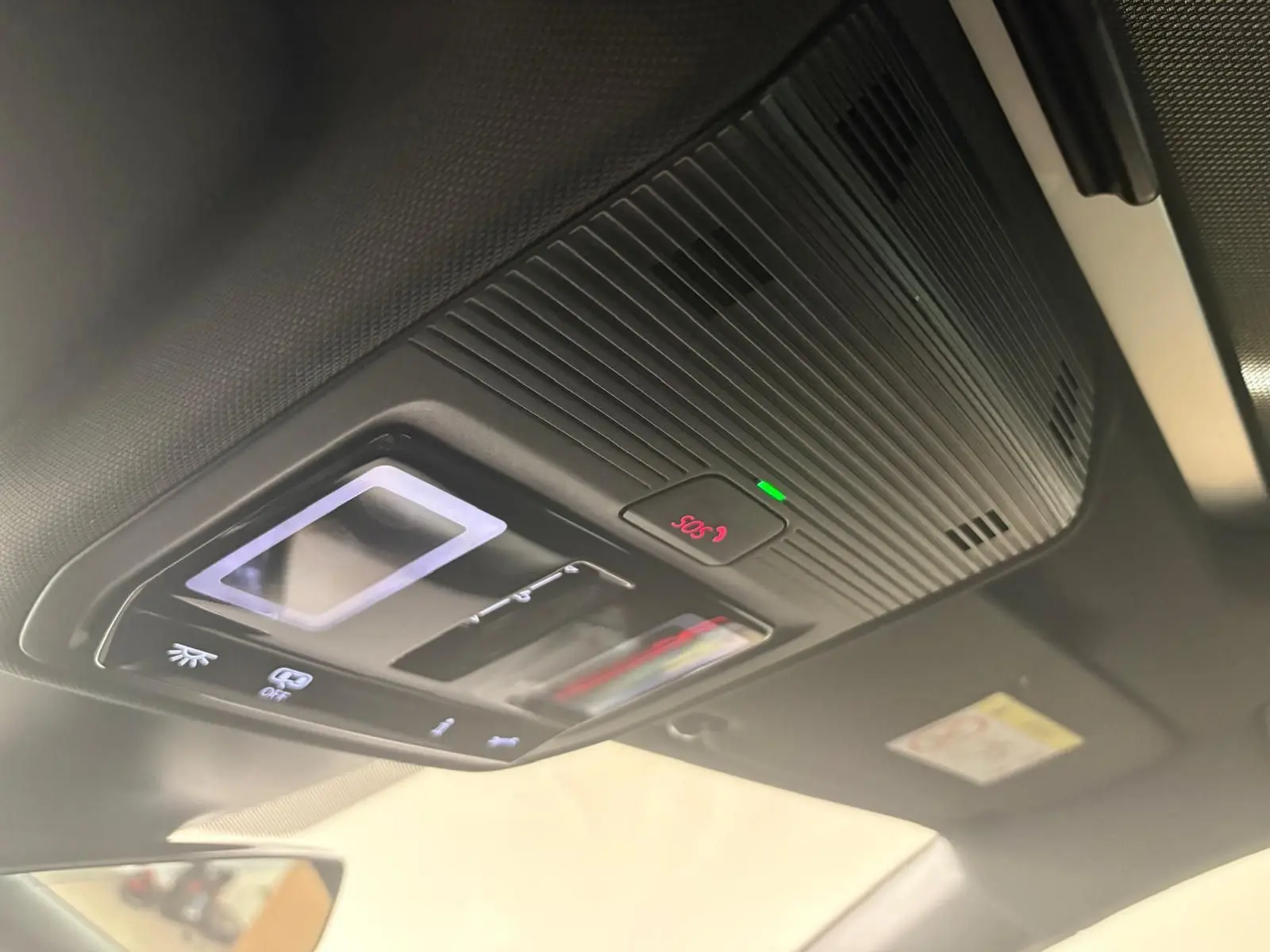 Vue en gros plan du panneau de commandes du toit ouvrant et de l'alerte SOS à l'intérieur d'une CUPRA Leon blanc Nevada 2024.