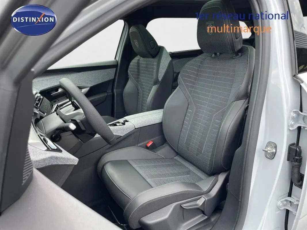 Vue intérieure côté conducteur du Peugeot 5008 Hybrid 145 GT 2025, sièges noirs avec détails gris et volant visible.