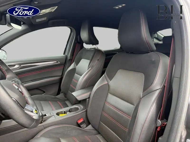 Vue intérieure côté conducteur et passager avant de la Renault Arkana 2023 avec sièges cuir-suédine noir à surpiqûres rouges.