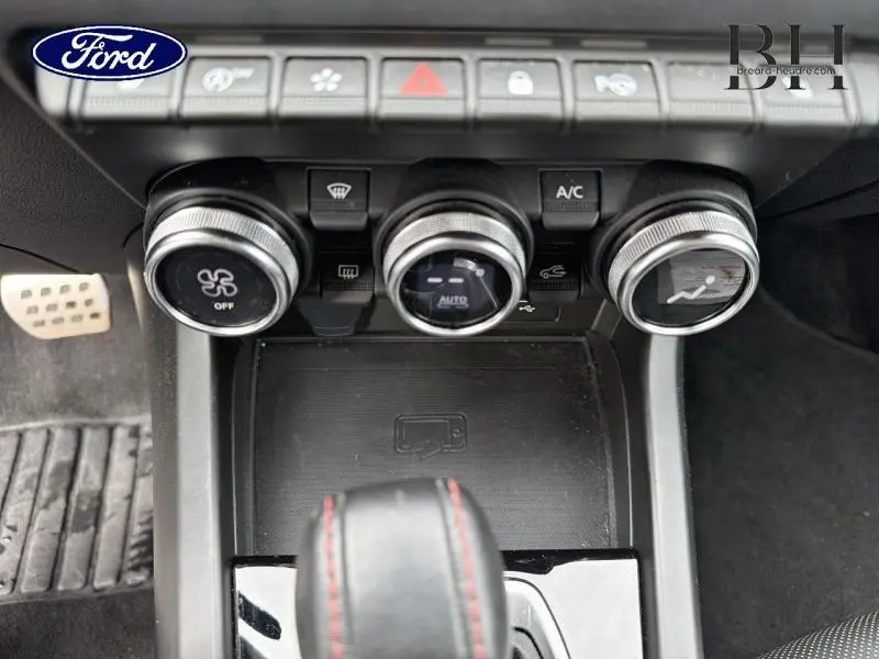 Vue rapprochée des commandes de climatisation et de la console centrale d'un Renault Arkana gris métallisé 2023.