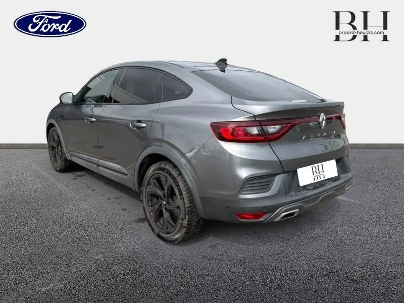 Vue 3/4 arrière droite d'un Renault Arkana gris métallisé avec feux LED et jantes noires.