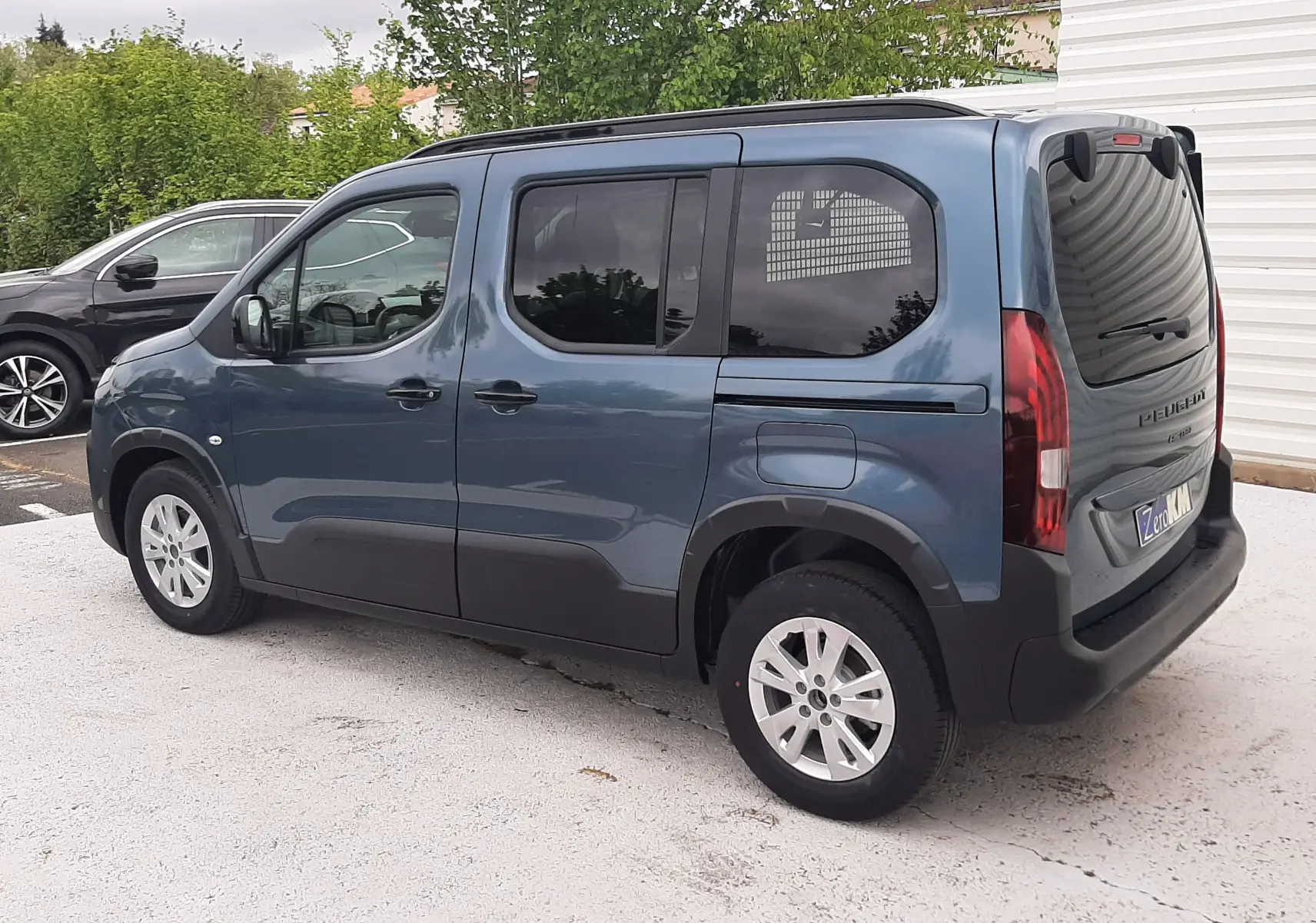 Peugeot Rifter Bleu Kiama en vue 3/4 arrière droit, avec vitres teintées et jantes alliage 16 pouces.