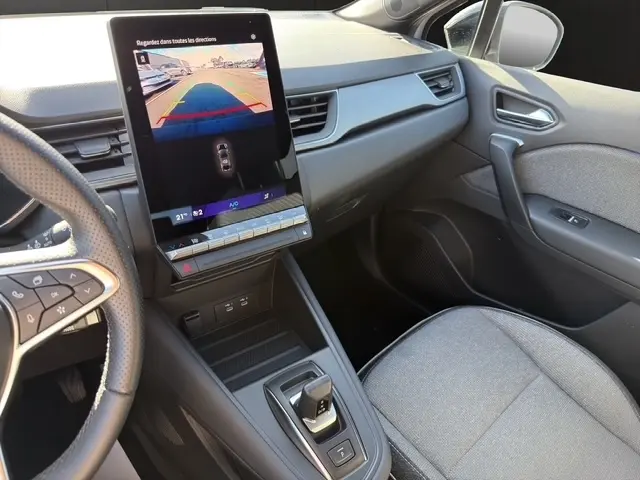 Vue intérieure côté passager du Renault Symbioz gris clair 2025, avec écran tactile central vertical et volant multifonctions.