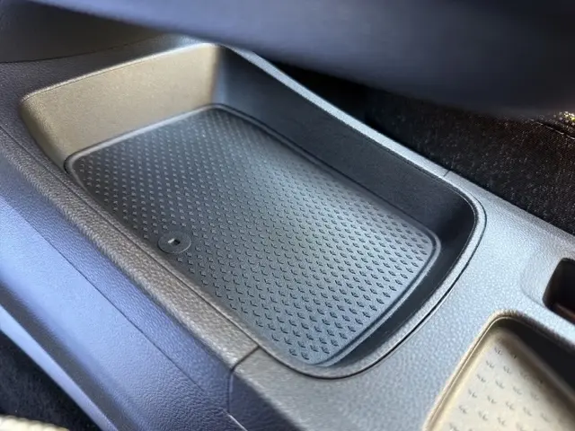 Gros plan sur le compartiment de rangement central noir du Renault Symbioz techno E-Tech hybride 2025, intérieur moderne.