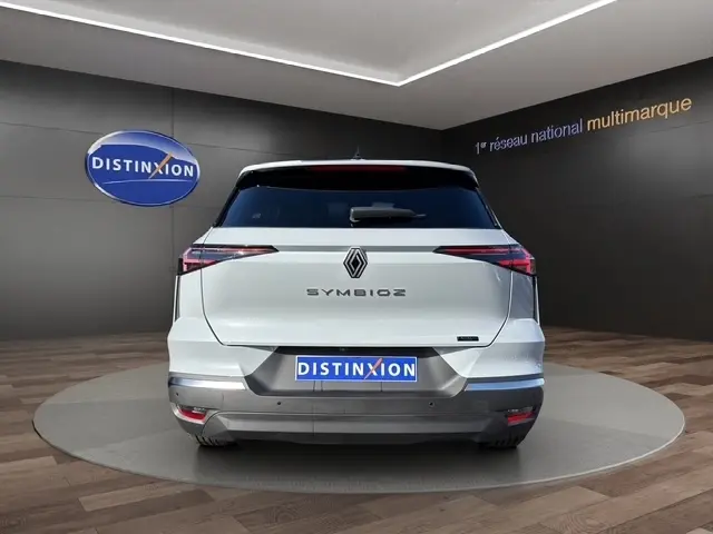 Vue arrière du Renault SYMBIOZ gris clair 2025, avec feux LED effilés et logo central distinctif sur fond noir.