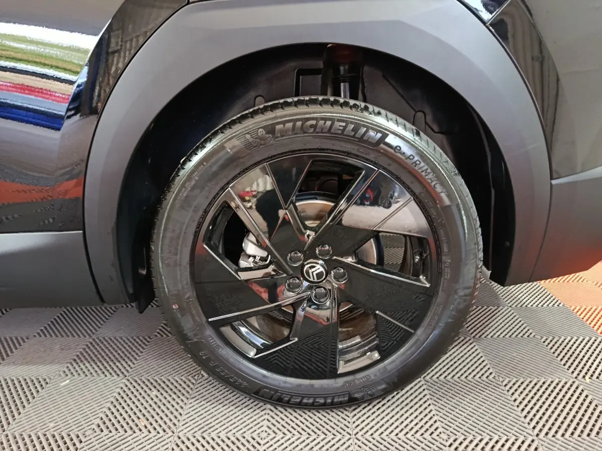Gros plan sur la roue avant droite noire avec jante en alliage brillant du Citroën C5 Hybride 2026.
