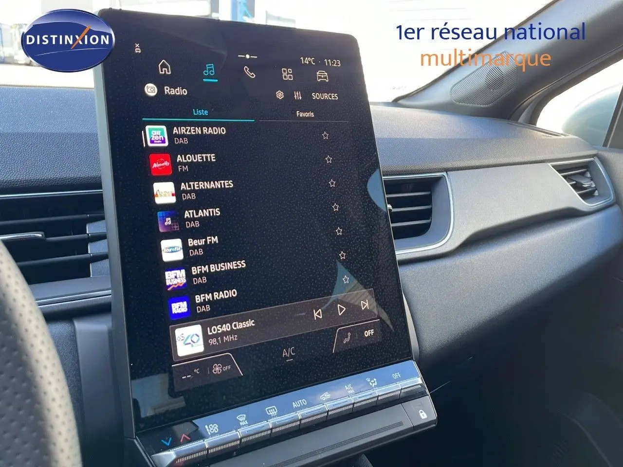 Vue intérieure du tableau de bord du Renault Captur E-Tech blanc nacré, avec écran tactile central affichant les radios DAB.
