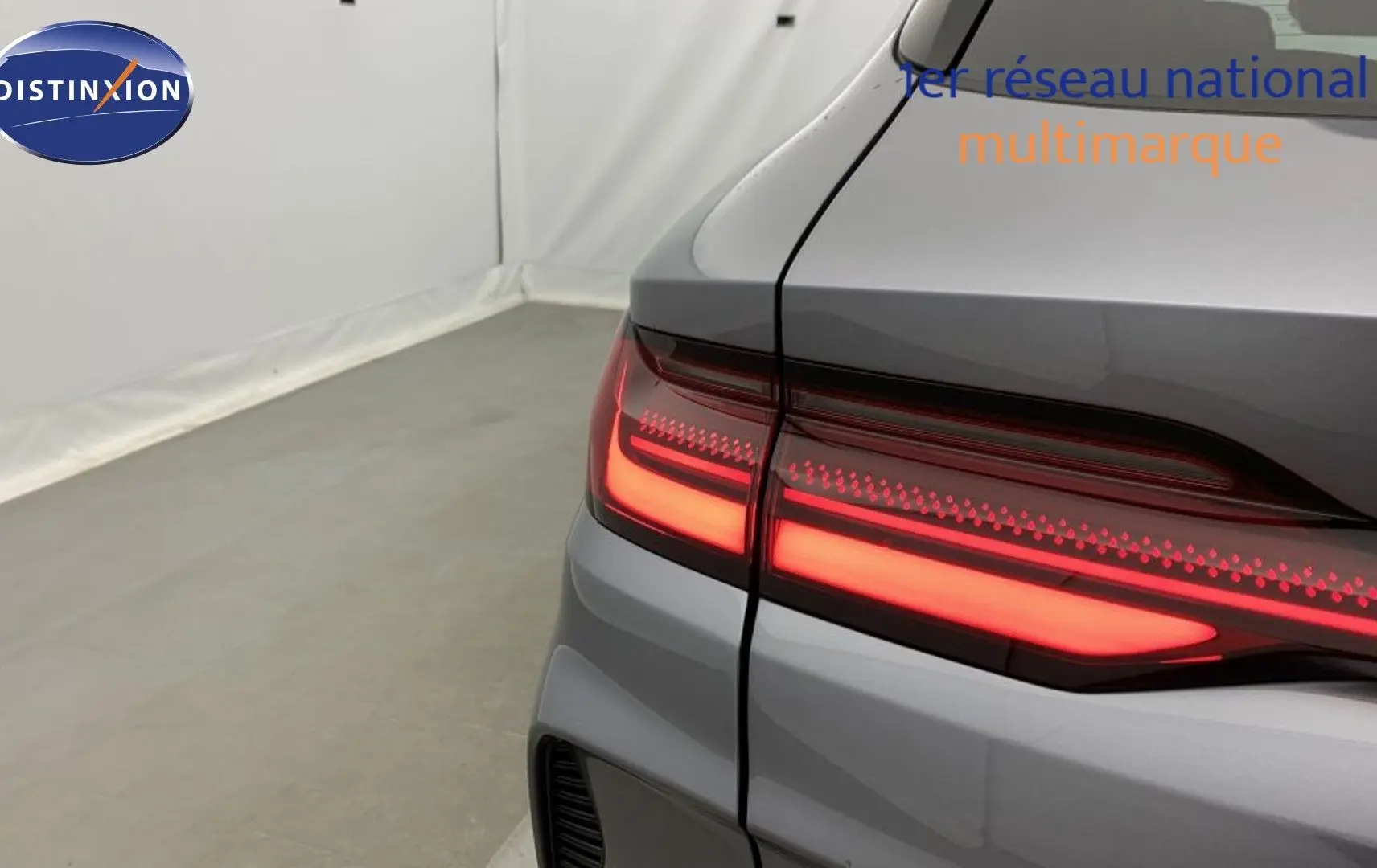 Vue arrière du coffre ouvert du BYD SEAL U Time Grey 2025 avec feux arrière LED allumés et deux sacs de rangement à l’intérieur.