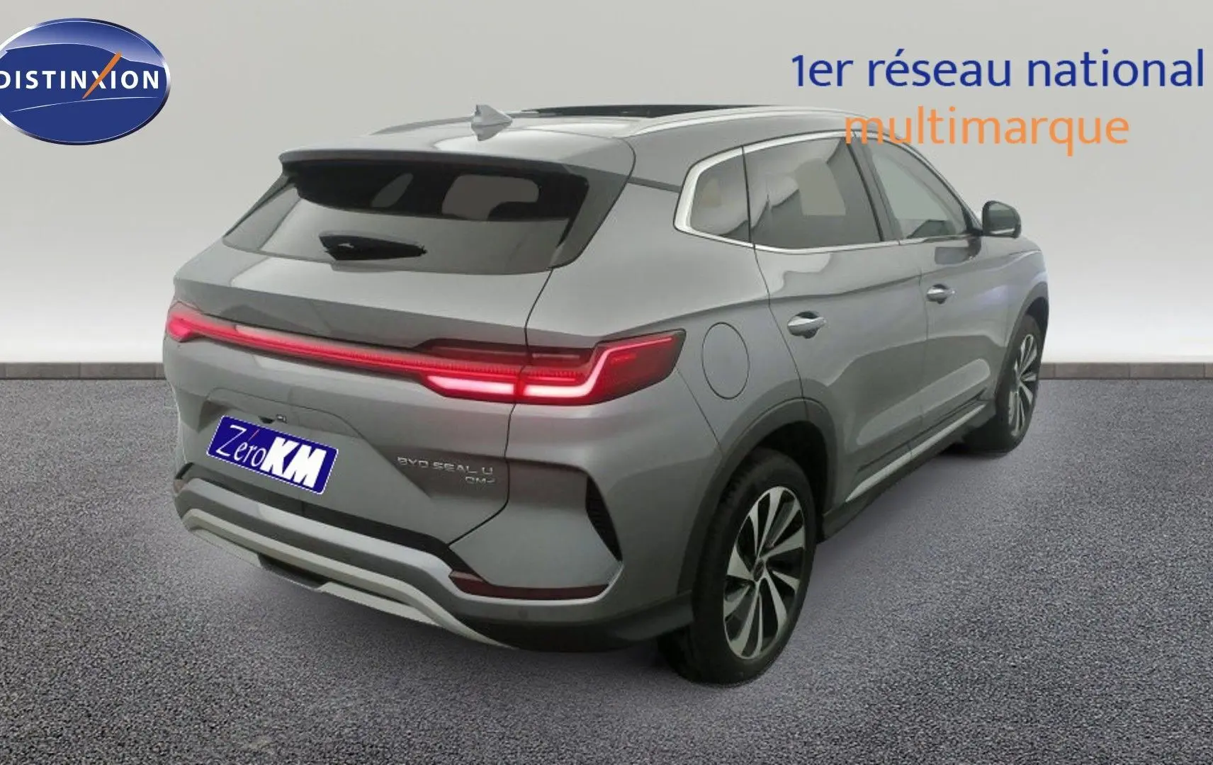 Vue 3/4 arrière droite du SUV BYD SEAL U gris Time Grey avec feux arrière LED allumés et jantes alliage bicolores.
