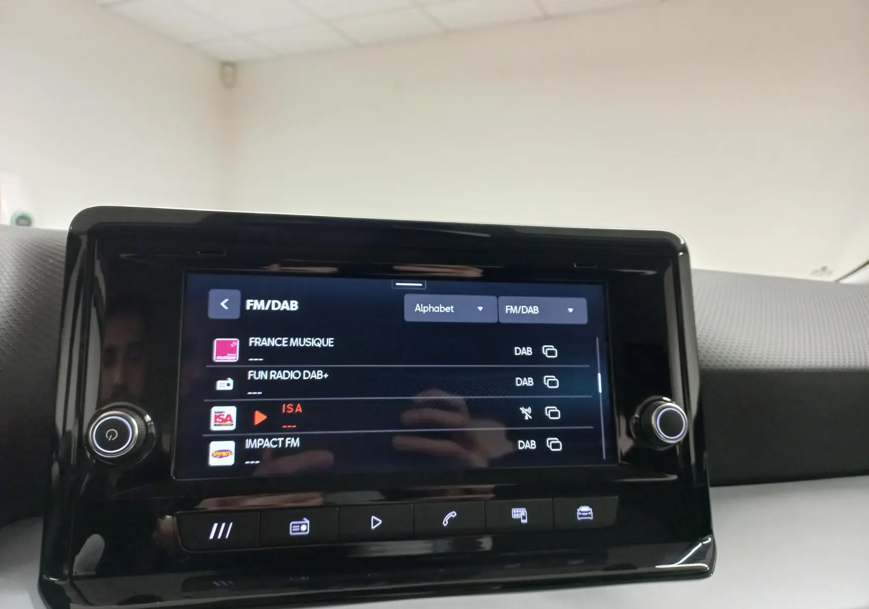 Écran tactile central du tableau de bord du SEAT Arona 2025 affichant les stations FM/DAB, intérieur gris.